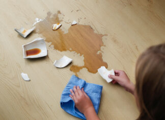 Wodoodporna podłoga do kuchni i łazienki – panele winylowe VIN IN A broken cup of coffee fell on laminate, coffee spilled on floor.